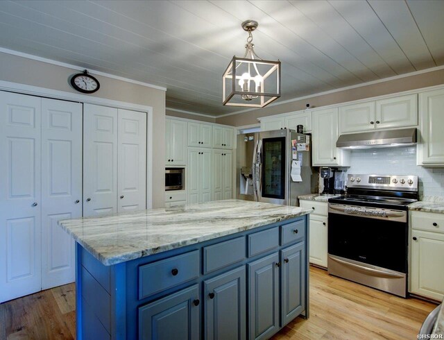 kitchen featuring hanging light fixtures, appliances with stainless steel finishes, ornamental molding, white cabinetry, and under cabinet range hood