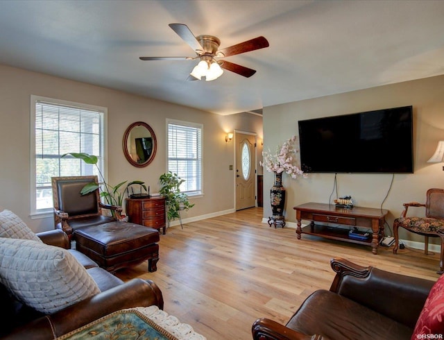 living area with light wood-style floors, plenty of natural light, baseboards, and a ceiling fan