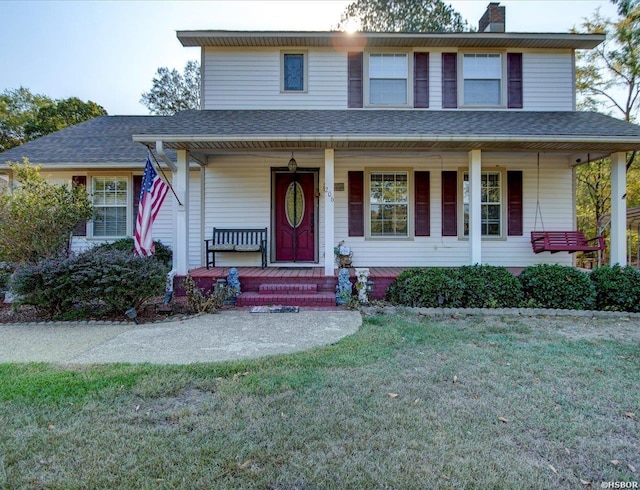 view of front of property featuring roof with shingles, a porch, a chimney, and a front lawn