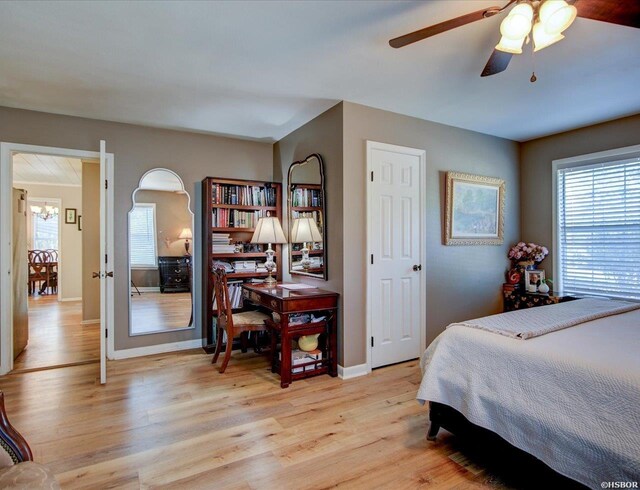 bedroom featuring multiple windows, light wood-style flooring, and baseboards