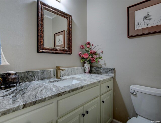 half bath featuring toilet and vanity