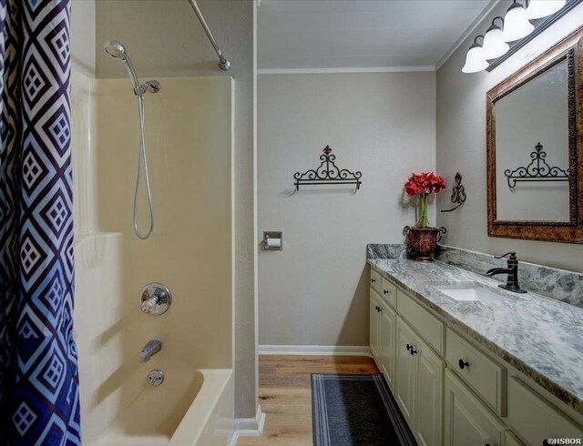 bathroom featuring ornamental molding, shower / bath combo, vanity, wood finished floors, and baseboards