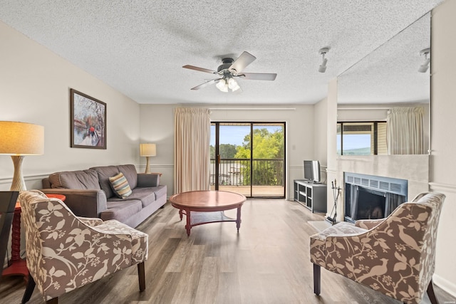 5371 Central Ave Unit 5L, Hot Springs, AR 71913 - living room with wood finished floors, a ceiling fan, a fireplace, and a textured ceiling