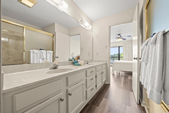 5371 Central Ave Unit 5L, Hot Springs, AR 71913 - bathroom featuring a textured ceiling, wood finished floors, double vanity, an enclosed shower, and ensuite bathroom