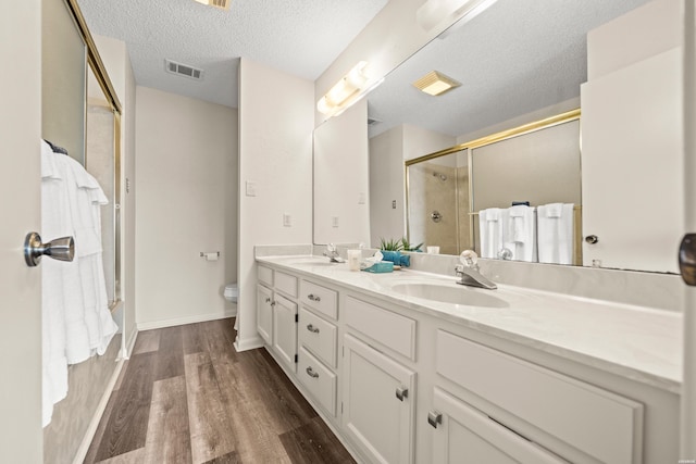 5371 Central Ave Unit 5L, Hot Springs, AR 71913 - bathroom with double vanity, wood finished floors, a shower with shower door, and a textured ceiling