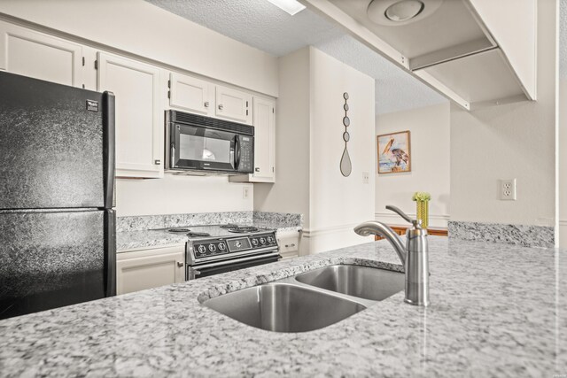 5371 Central Ave Unit 5L, Hot Springs, AR 71913 - kitchen featuring black appliances, white cabinets, light stone counters, and a textured ceiling