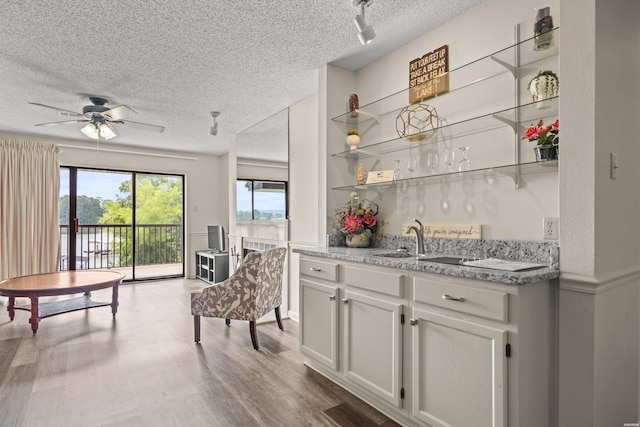 5371 Central Ave Unit 5L, Hot Springs, AR 71913 - kitchen featuring open shelves, a textured ceiling, wood finished floors, ceiling fan, and light stone countertops
