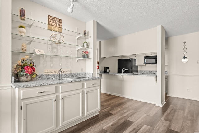 5371 Central Ave Unit 5L, Hot Springs, AR 71913 - kitchen featuring black appliances, dark wood-style floors, a textured ceiling, open shelves, and white cabinets