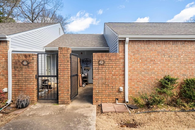 exterior space with brick siding and roof with shingles