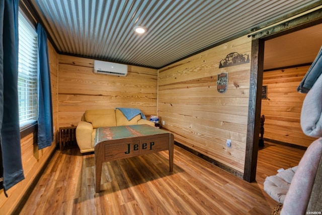 152 Anderson Loop, Amity, AR 71921 - bedroom featuring an AC wall unit, wooden walls, and wood finished floors