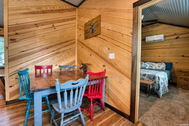 152 Anderson Loop, Amity, AR 71921 - dining space featuring a wall mounted air conditioner, wood walls, wood finished floors, and vaulted ceiling