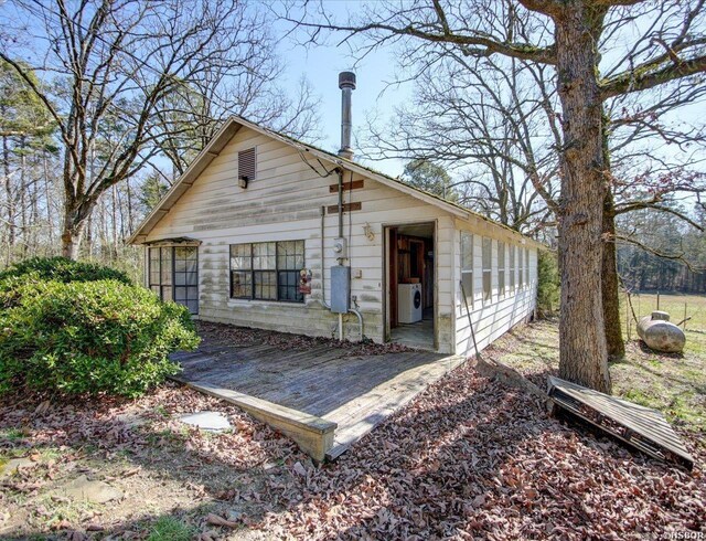 rear view of property featuring washer / clothes dryer and a wooden deck