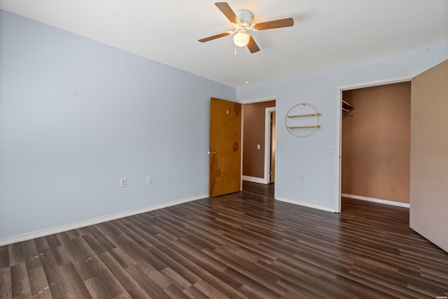 spare room featuring dark wood-style floors, a ceiling fan, and baseboards