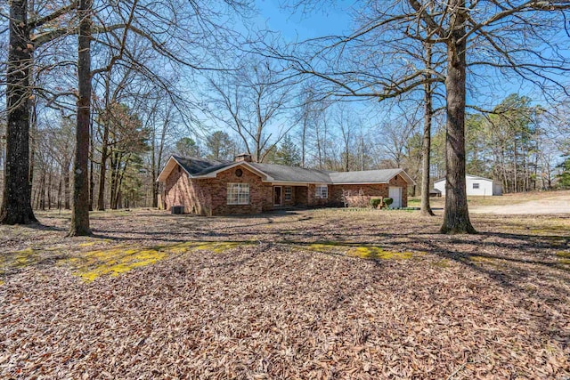 view of front of home featuring brick siding and a chimney