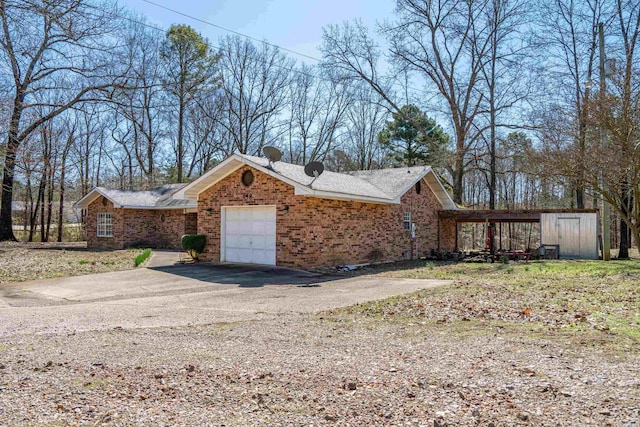 view of side of home with a garage, brick siding, and aphalt driveway