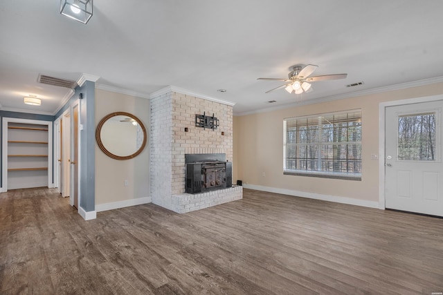 unfurnished living room featuring visible vents, wood finished floors, baseboards, and ornamental molding