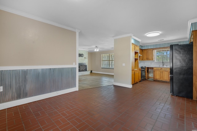 kitchen featuring ornamental molding, electric stove, open floor plan, freestanding refrigerator, and brick floor