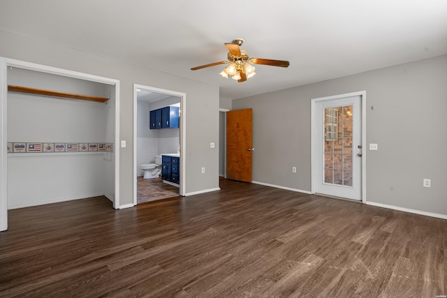 unfurnished bedroom featuring connected bathroom, a ceiling fan, baseboards, and wood finished floors