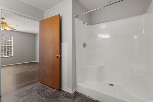 bathroom with a ceiling fan, baseboards, and walk in shower