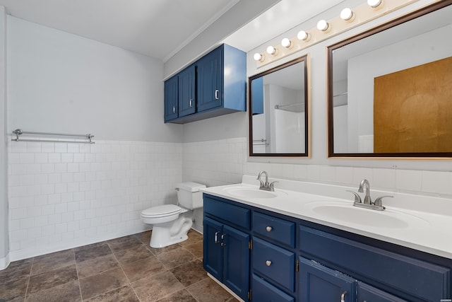 full bath featuring a sink, toilet, tile walls, and double vanity