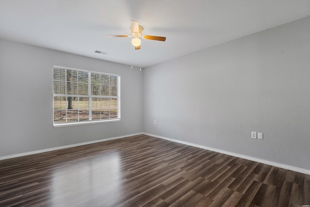 unfurnished room featuring visible vents, baseboards, dark wood-type flooring, and a ceiling fan