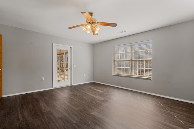 spare room with visible vents, ceiling fan, baseboards, and wood finished floors