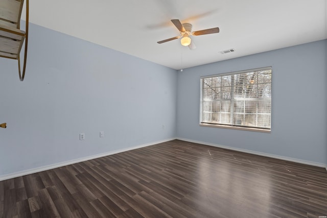 empty room with baseboards, visible vents, dark wood-style flooring, and ceiling fan