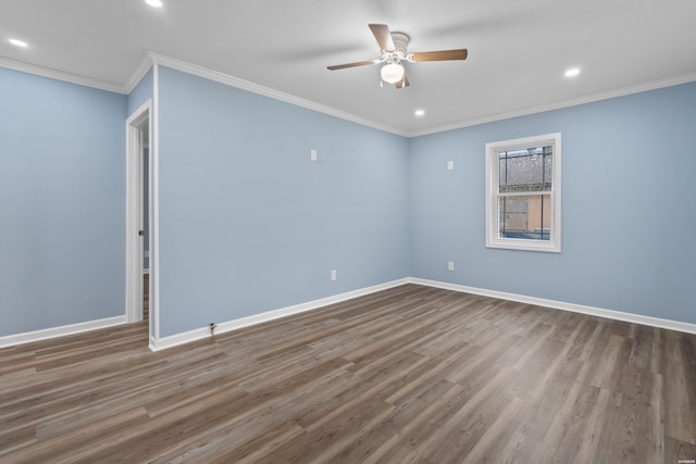 spare room featuring crown molding, baseboards, and wood finished floors