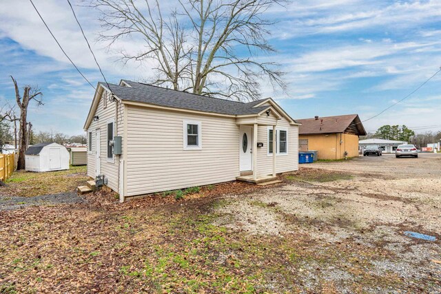 view of front of home with an outbuilding, dirt driveway, and a shed