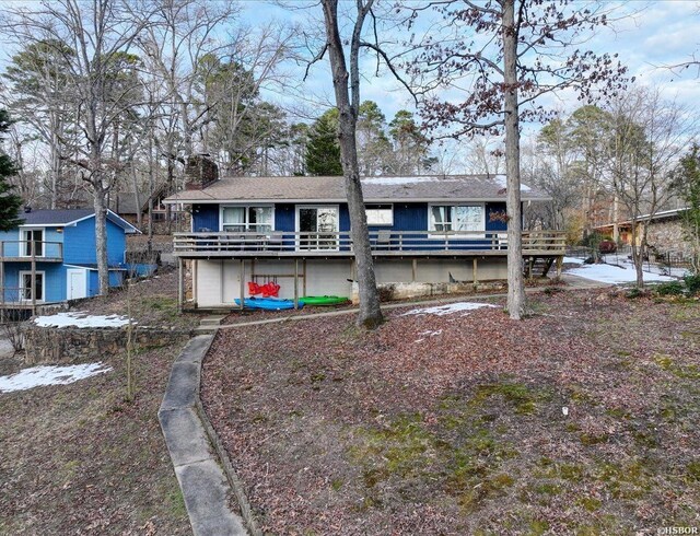 view of front of home featuring a chimney and a wooden deck