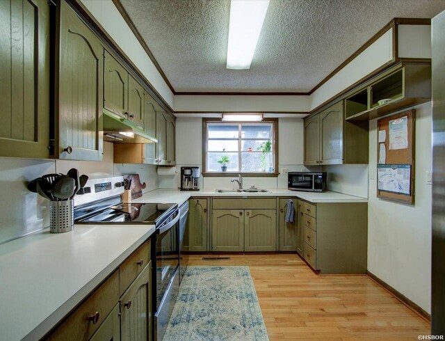 kitchen featuring stainless steel electric range oven, light countertops, a sink, and green cabinetry