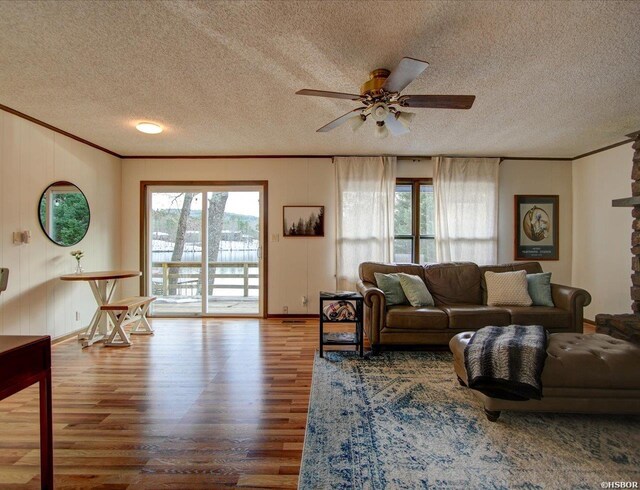 living room with plenty of natural light, wood finished floors, and crown molding