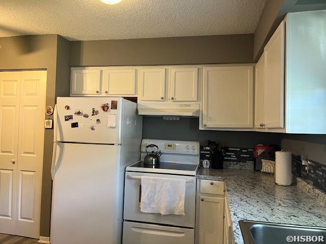 600 Higdon Ferry Rd, Hot Springs, AR 71913 - kitchen featuring white appliances, under cabinet range hood, white cabinetry, a textured ceiling, and light stone countertops