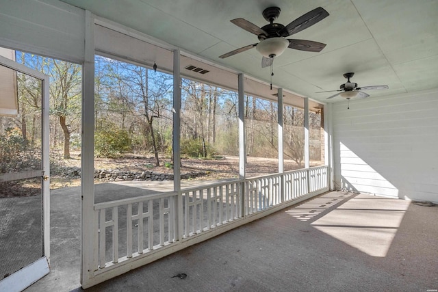 unfurnished sunroom featuring ceiling fan