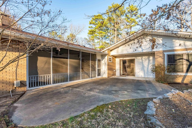 back of property featuring a ceiling fan, a sunroom, and brick siding