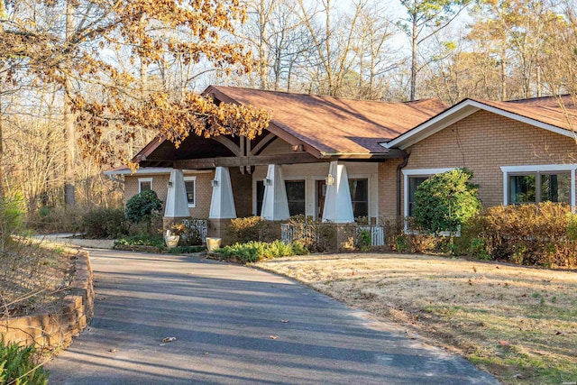 craftsman house with a porch and brick siding