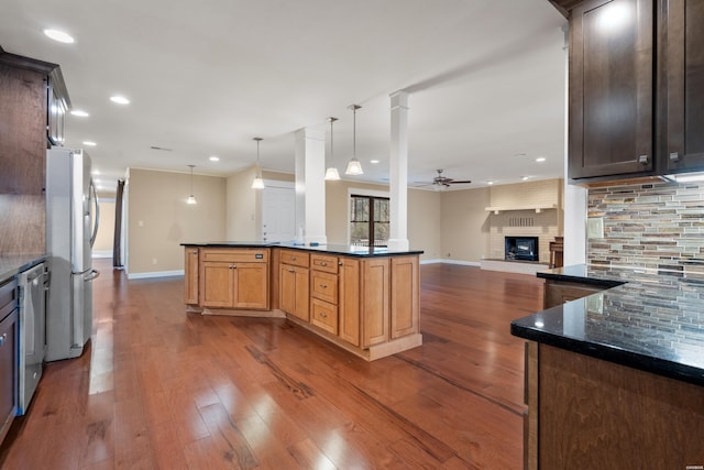 kitchen featuring decorative backsplash, a ceiling fan, dark wood-style flooring, stainless steel appliances, and a fireplace