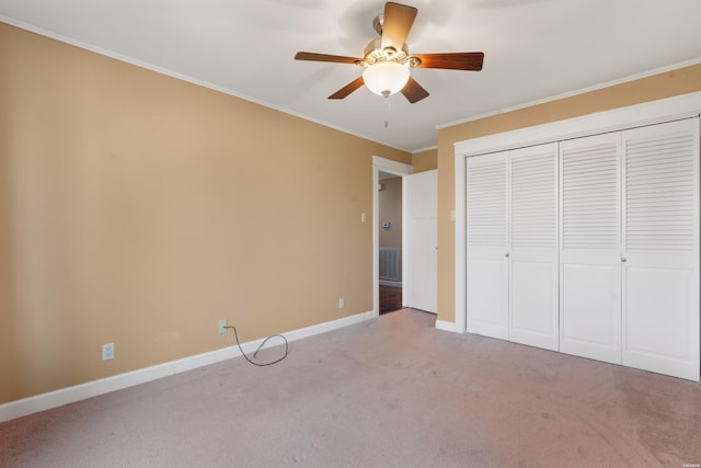 unfurnished bedroom with baseboards, visible vents, ornamental molding, carpet floors, and a closet