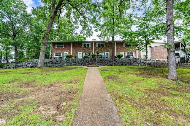 view of front of house featuring a front lawn and brick siding