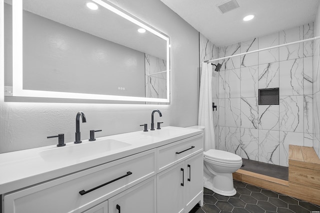 bathroom featuring toilet, a stall shower, visible vents, and a sink