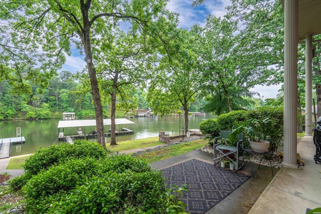 view of patio with a water view and a boat dock