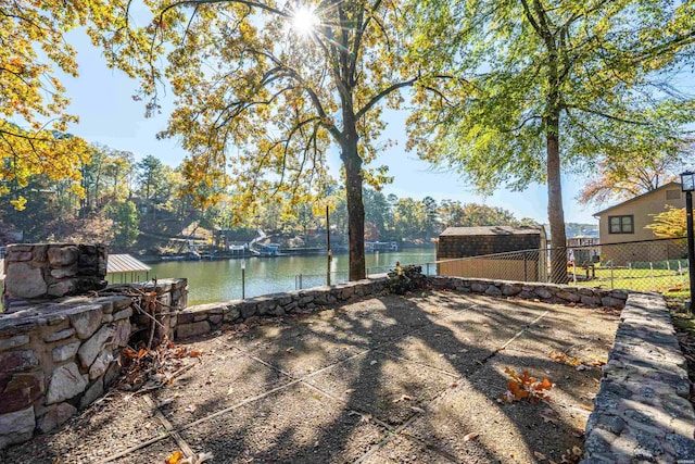 exterior space with a water view and fence