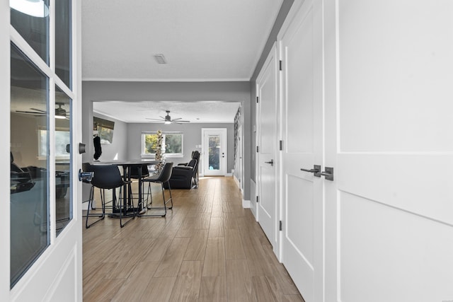 interior space with baseboards, light wood-style flooring, and a ceiling fan