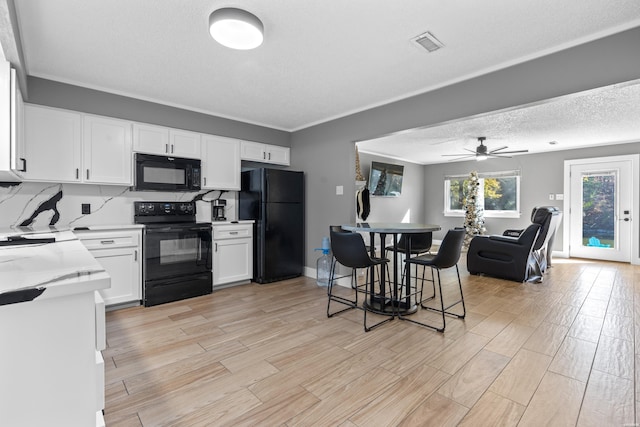 kitchen with visible vents, white cabinets, open floor plan, light countertops, and black appliances