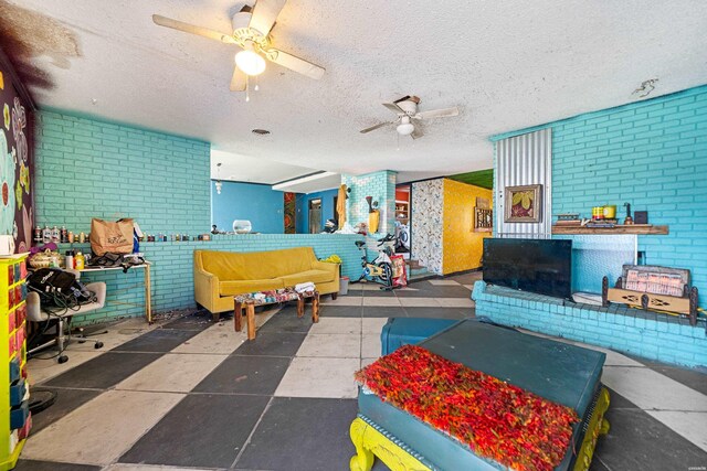 interior space featuring a textured ceiling, brick wall, and ceiling fan