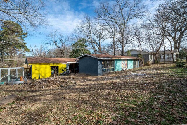 rear view of property featuring an outdoor structure