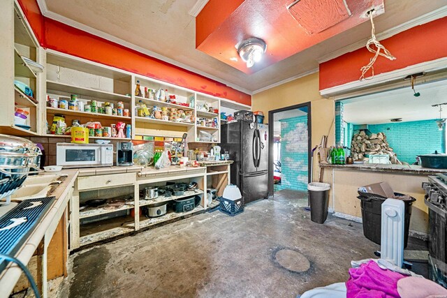 misc room featuring concrete flooring, a workshop area, and crown molding