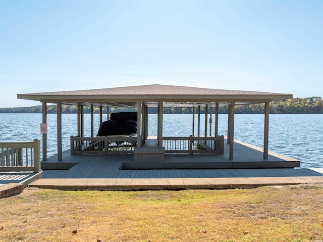 view of dock featuring a yard, a water view, and boat lift