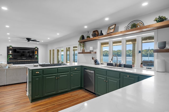 kitchen featuring open shelves, a peninsula, light countertops, and a sink