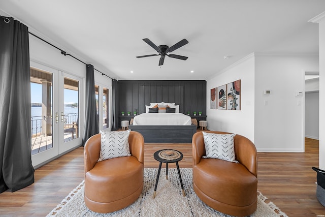 bedroom with a water view, access to exterior, wood finished floors, and french doors